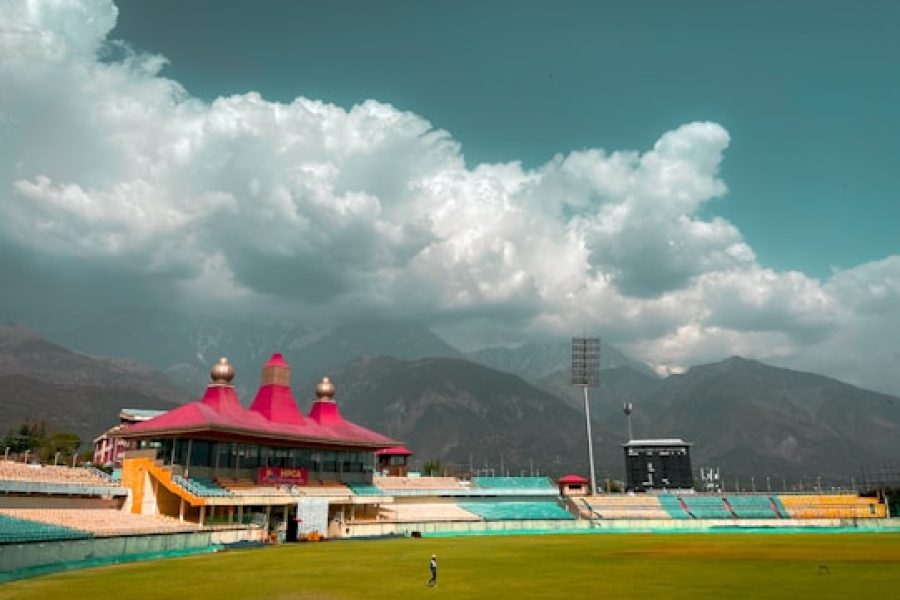 people playing soccer on field under white clouds and blue sky during daytime